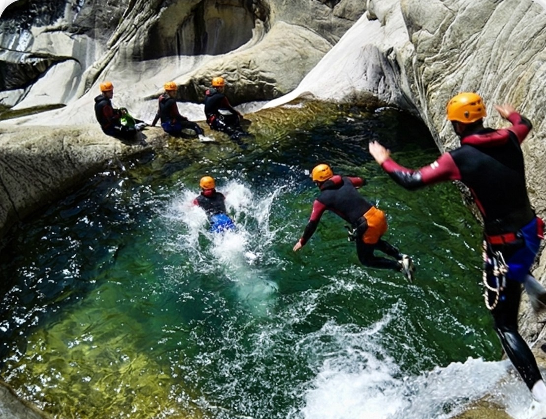 Groupe en canyoning sautant dans une vasque d'eau turquoise à Bavella